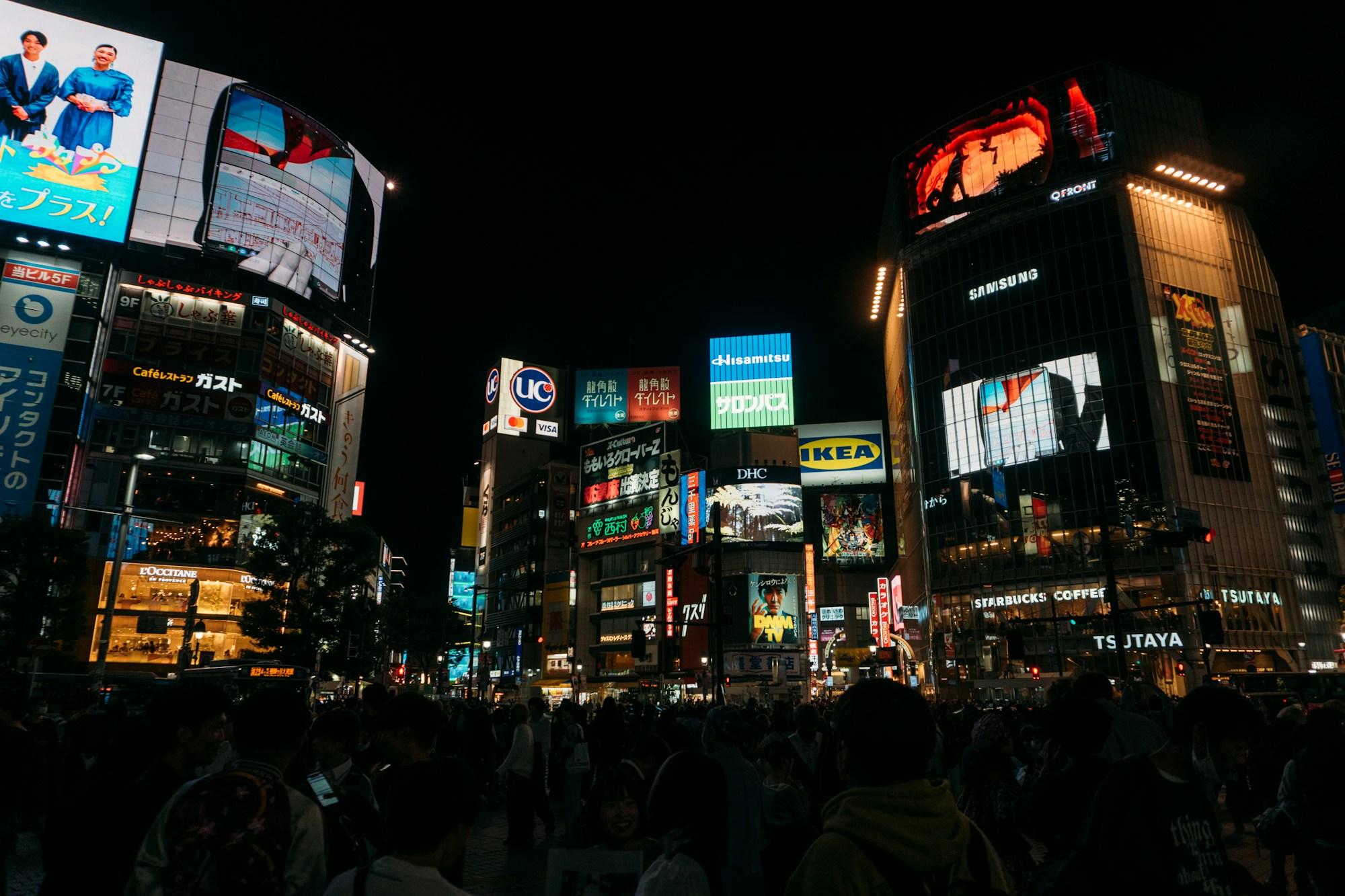 Crowded city crossing surrounded by illuminated signs